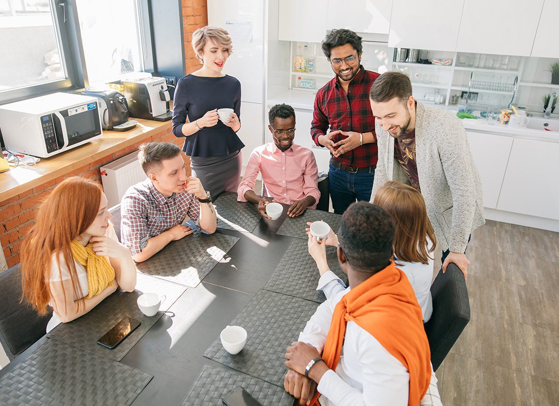 Insurance Solutions - Group of Friendly Professionals Smile and Laugh During a Meeting